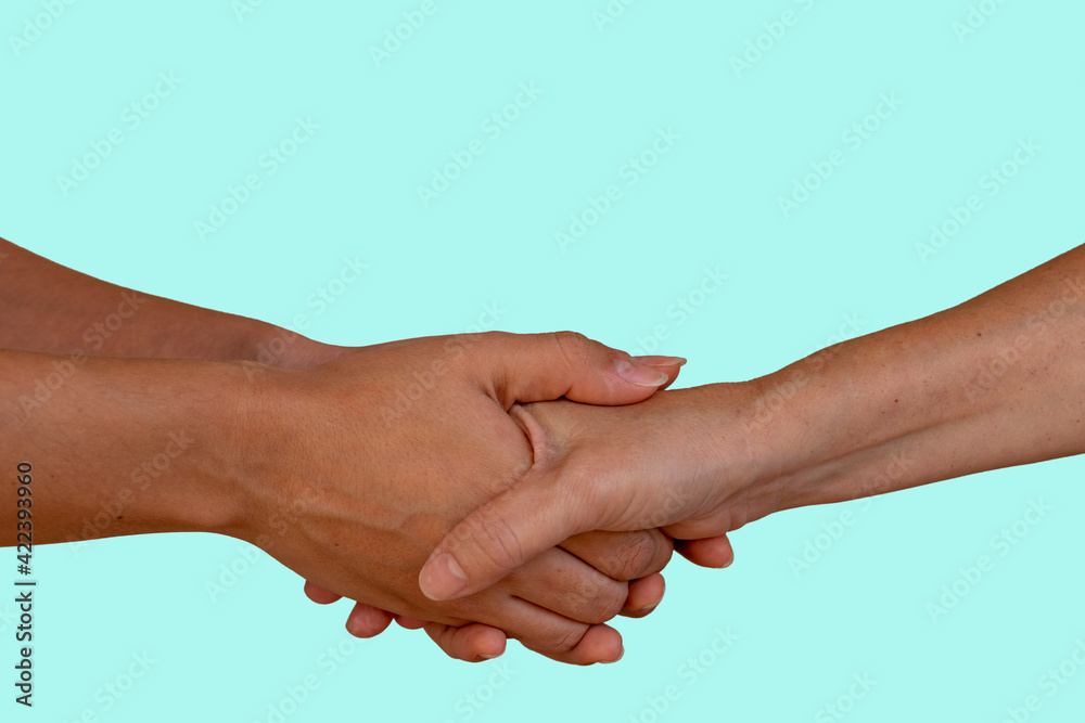 Two people holding hands, elderly and young people shaking hands, helping hand and world peace concept with copy space. blue background. Two people holding hands, elderly and young people shaking hands, helping hand and world peace concept with copy space. blue background.