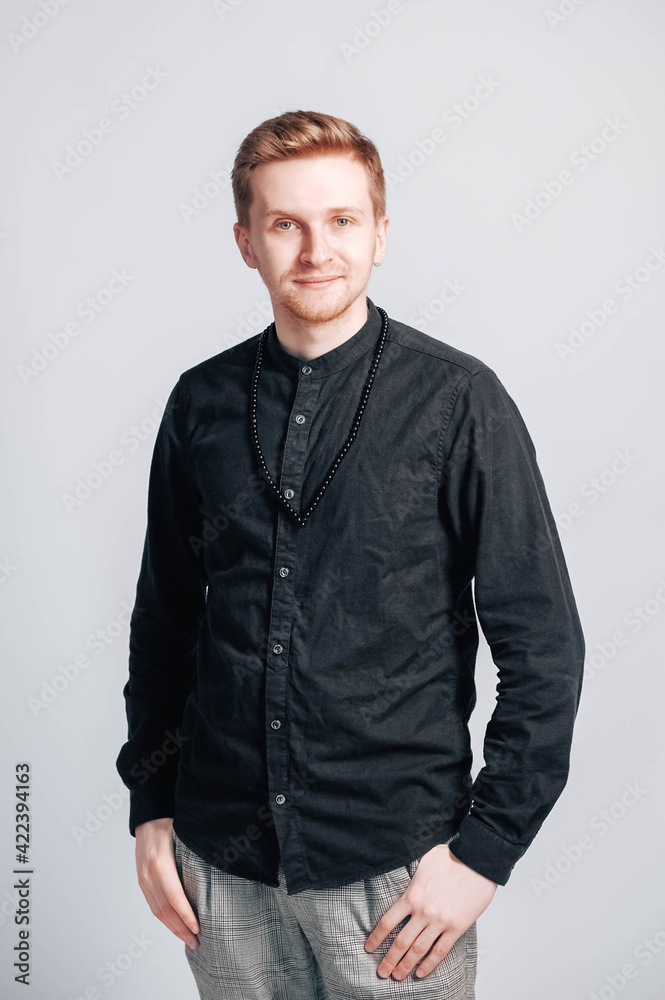 Fototapeta premium Portrait of a young man in a black shirt on a white background. Copy, empty space for text