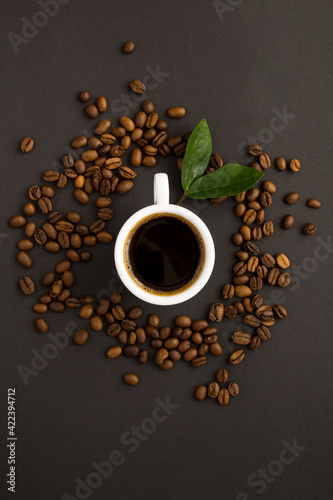 Top view of coffee cup and coffee beans on the black background. Close-up.