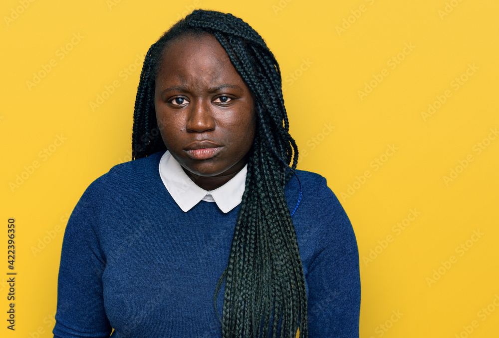 Young black woman with braids wearing casual clothes skeptic and nervous, frowning upset because of problem. negative person. Young black woman with braids wearing casual clothes skeptic and nervous, frowning upset because of problem. negative person.