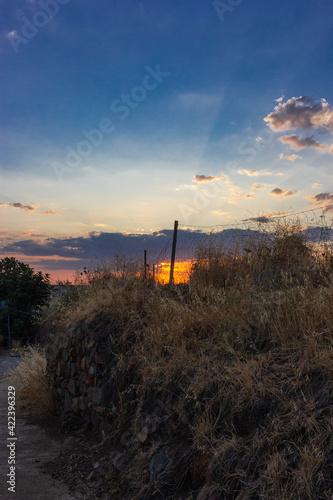 Stone wall in a field in Andalusia with a sunset sky