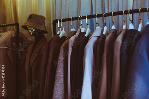 Brown beige warm cozy clothes with different material hanging on a clothing rack , clearly visible texture. Stylish fall winter season clothing. Copy space.