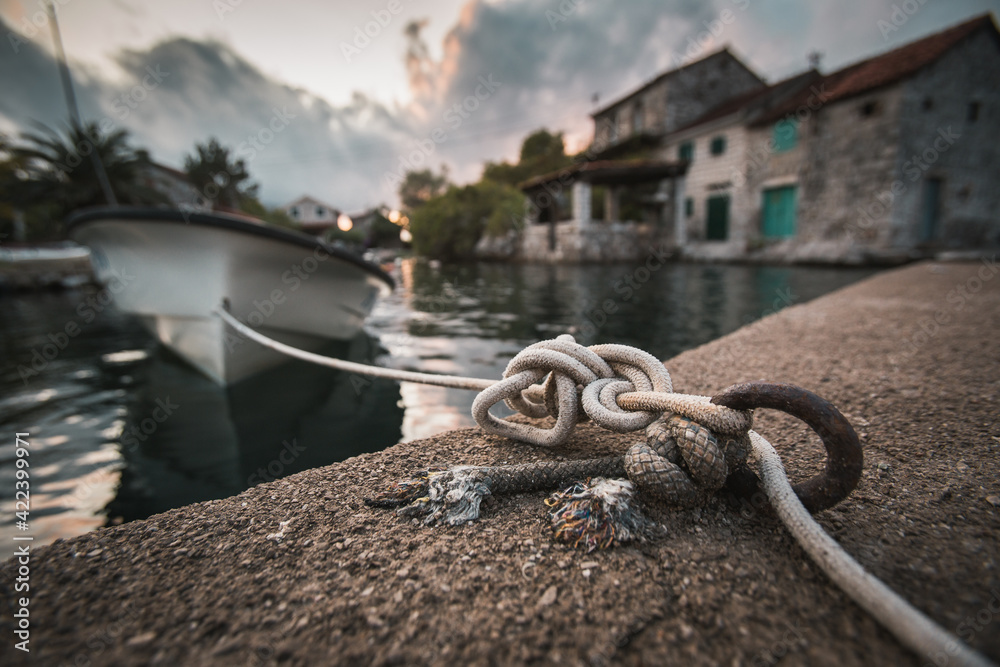 Naklejka premium Boat tied by rope on the dock