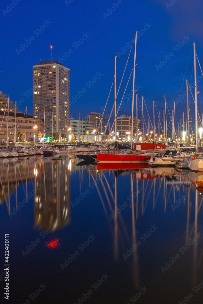 Fototapeta premium Oostende (Ostend) yacht marina harbor at night in vertical format, Belgium.
