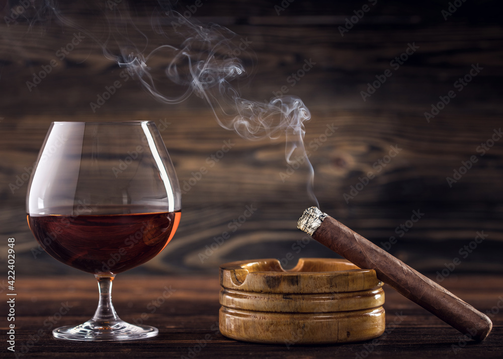 Cognac and cigar. Glass of cognac or brandy with cigars from Cuba Havana  and ashtray on