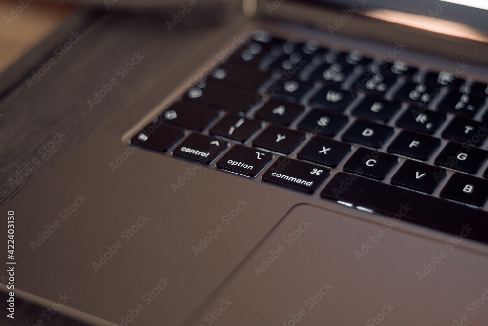 laptop computer keyboard at home during isolation on the wooden table in the kitchen laptop computer keyboard at home during isolation on the wooden table in the kitchen