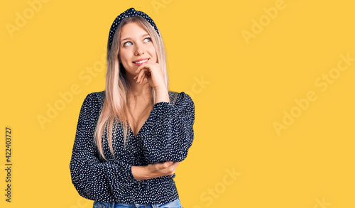 Obraz na plátně Young beautiful blonde woman wearing casual clothes with hand on chin thinking about question, pensive expression