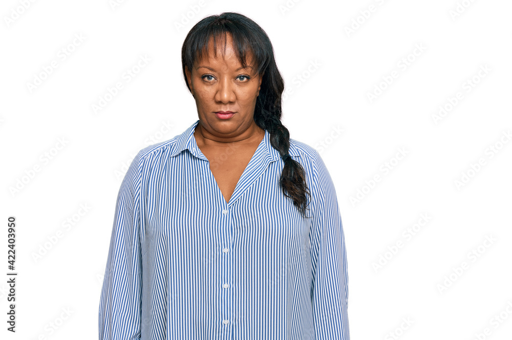 Hispanic middle age woman wearing casual clothes with serious expression on face. simple and natural looking at the camera. Hispanic middle age woman wearing casual clothes with serious expression on face. simple and natural looking at the camera.