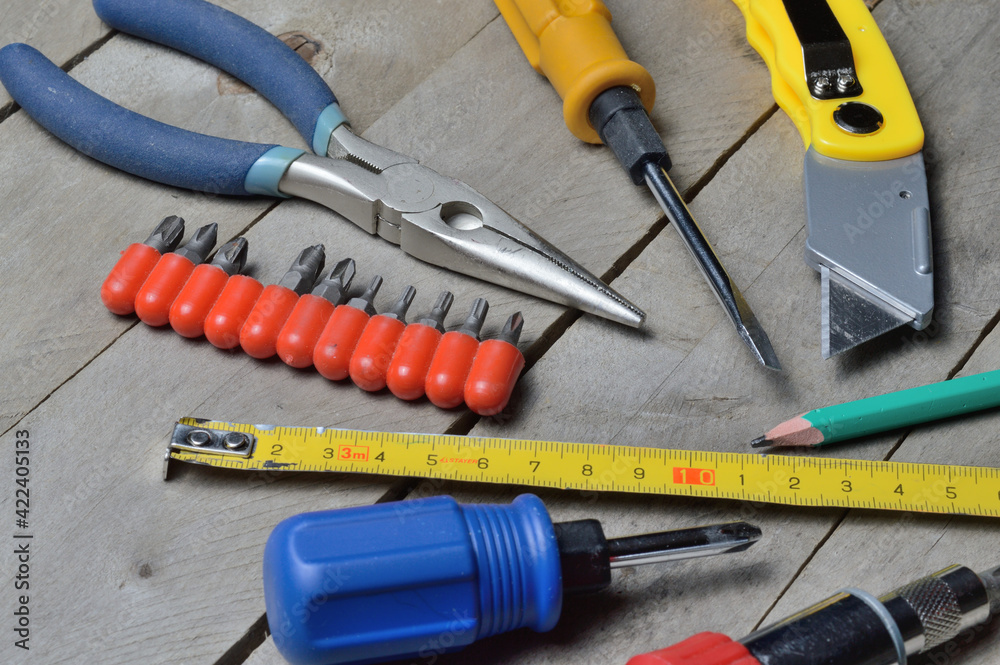 some home repair tools lie on a wooden background. close-up. some home repair tools lie on a wooden background. close-up.