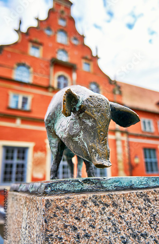 Standing pig as a bronze statue on the canal bridge in the city of Wismar.