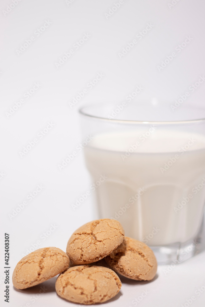 glass of milk near almond amaretti cookies isolated on white background. healthy breakfast snack glass of milk near almond amaretti cookies isolated on white background. healthy breakfast snack