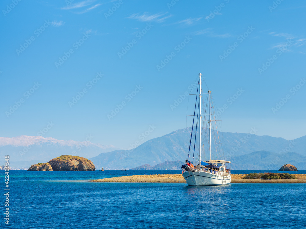 beautiful white sail yacht on the beach under blue sky in Turkey with copy space