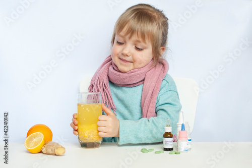 Sick Blonde baby girl with scarf and pills and vitamins