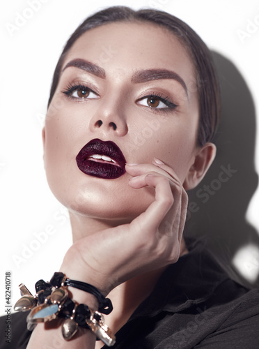 Beauty Fashion model girl with dark lips portrait, wearing stylish sexy woman portrait with perfect makeup, trendy accessories and fashion wear. Beauty trends. Perfect skin. White background