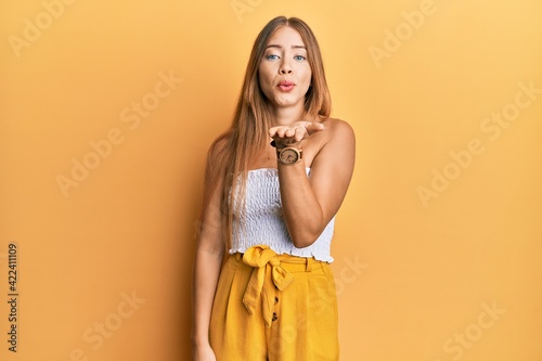 Obraz na plátne Beautiful young blonde woman wearing casual summer clothes looking at the camera blowing a kiss with hand on air being lovely and sexy