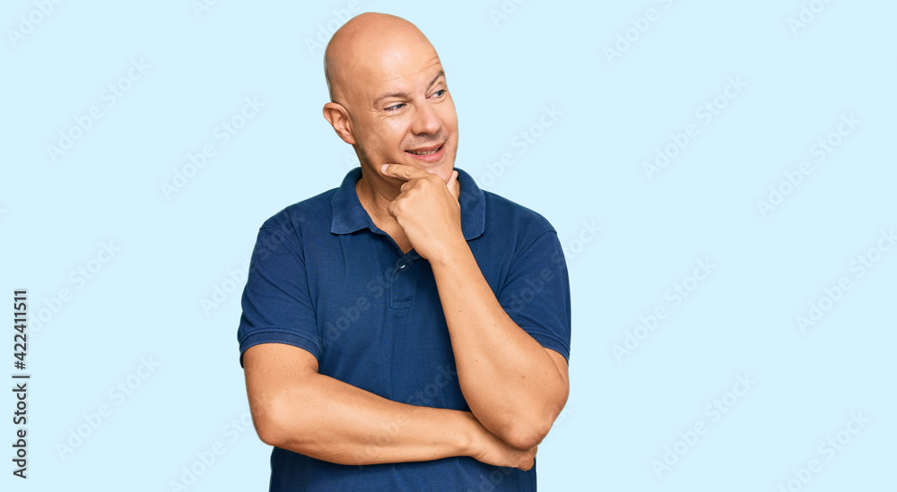 Fototapeta premium Middle age bald man wearing casual clothes with hand on chin thinking about question, pensive expression. smiling with thoughtful face. doubt concept.