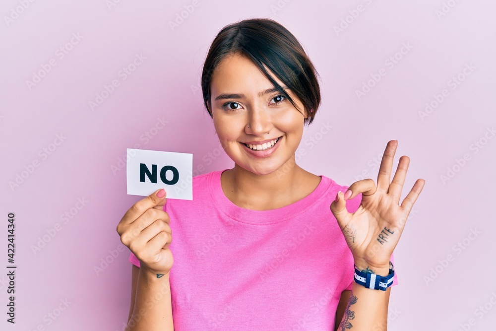 Beautiful young woman with short hair holding no word message doing ok sign with fingers, smiling friendly gesturing excellent symbol Beautiful young woman with short hair holding no word message doing ok sign with fingers, smiling friendly gesturing excellent symbol