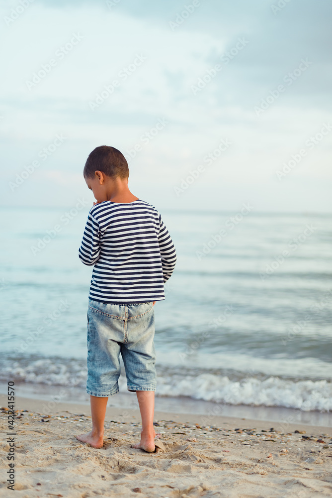Child running on the beach. Summer vacation. happy kid playing on beach at the sunset time Child running on the beach. Summer vacation. happy kid playing on beach at the sunset time