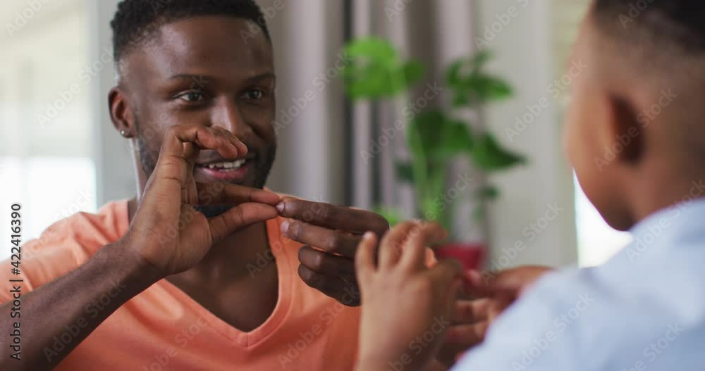 African american father teching his son sign language