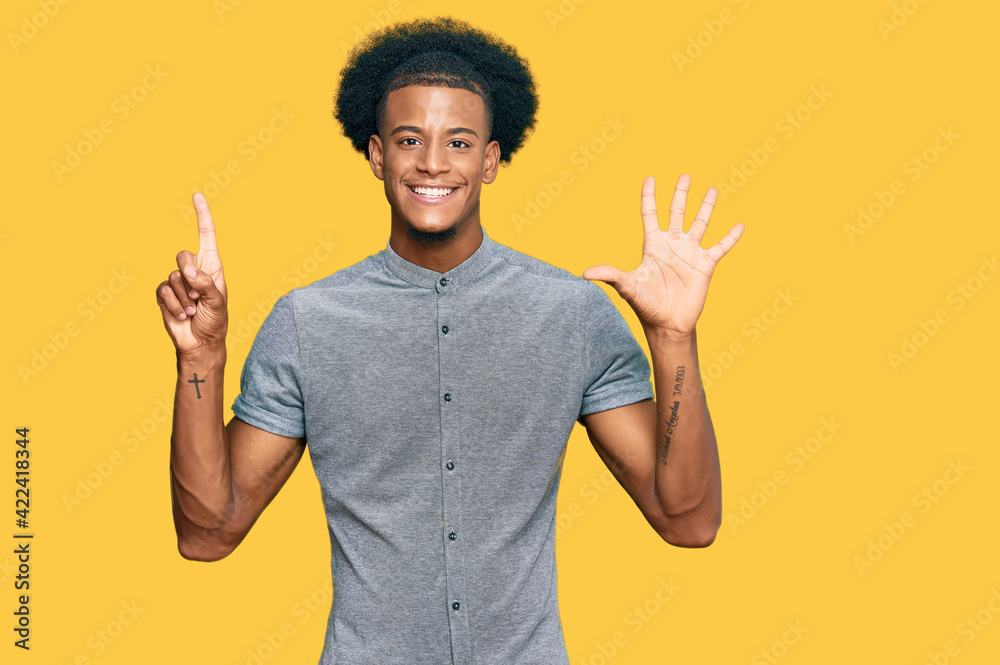 African american man with afro hair wearing casual clothes showing and pointing up with fingers number six while smiling confident and happy. African american man with afro hair wearing casual clothes showing and pointing up with fingers number six while smiling confident and happy.