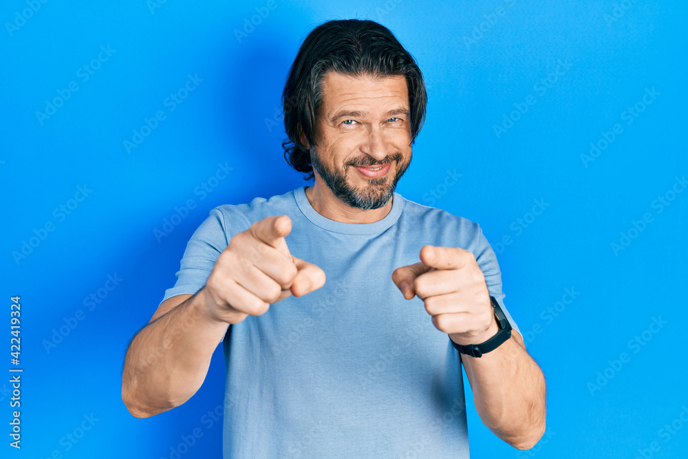 Middle age caucasian man wearing casual clothes pointing fingers to camera with happy and funny face. good energy and vibes. Middle age caucasian man wearing casual clothes pointing fingers to camera with happy and funny face. good energy and vibes.