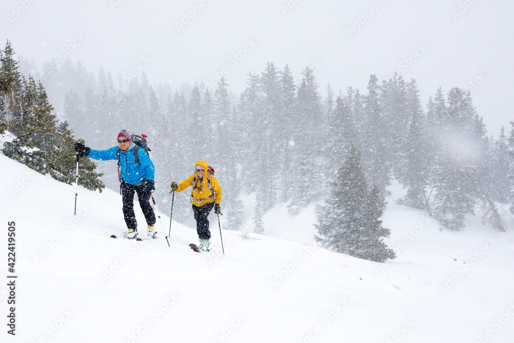 A couple backcountry skiing in Commodore Gulch, Red Mountain Pass, Uncompahgre National Forest, Ouray, Colorado. A couple backcountry skiing in Commodore Gulch, Red Mountain Pass, Uncompahgre National Forest, Ouray, Colorado.