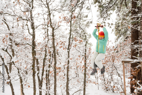 A girl riding a zip line after a fresh snow, Durango, Colorado.