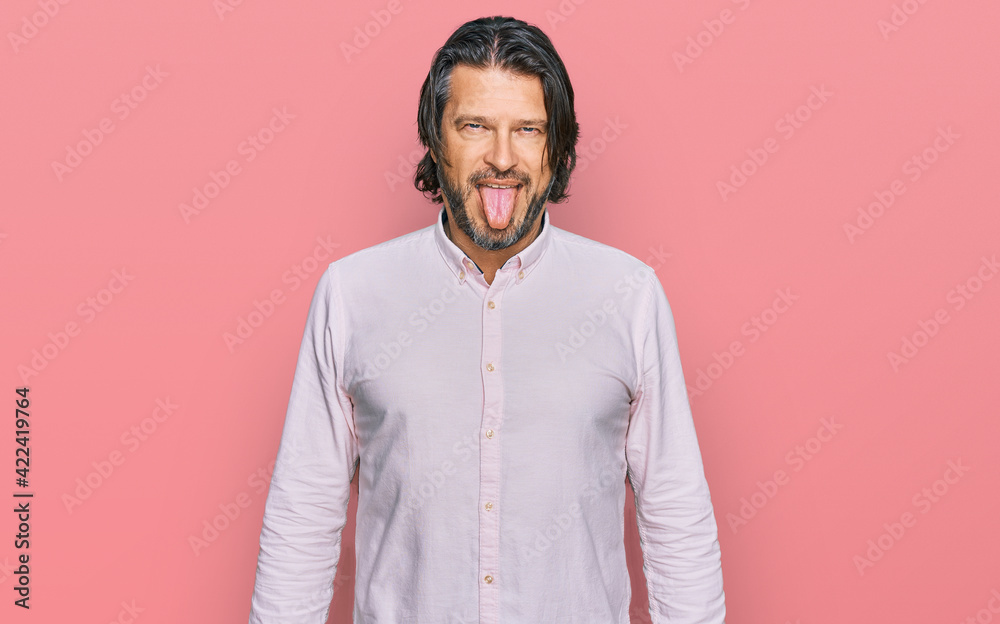 Middle age handsome man wearing business shirt sticking tongue out happy with funny expression. emotion concept. Middle age handsome man wearing business shirt sticking tongue out happy with funny expression. emotion concept.