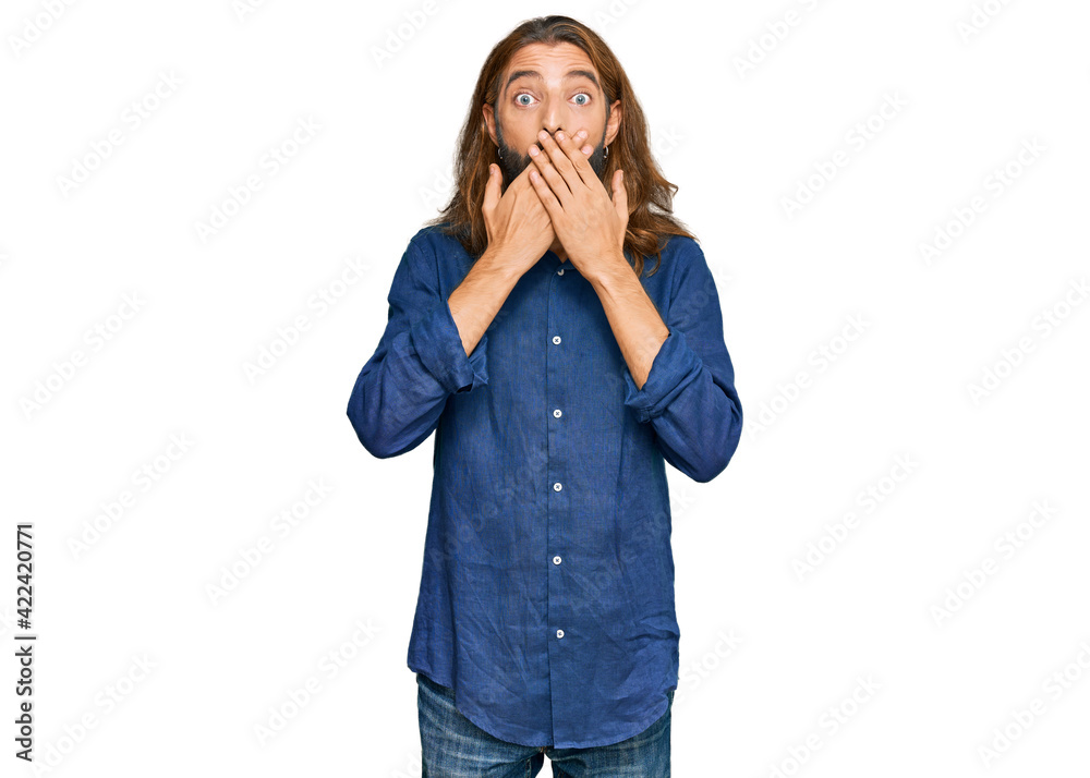 Attractive man with long hair and beard wearing casual clothes shocked covering mouth with hands for mistake. secret concept. Attractive man with long hair and beard wearing casual clothes shocked covering mouth with hands for mistake. secret concept.