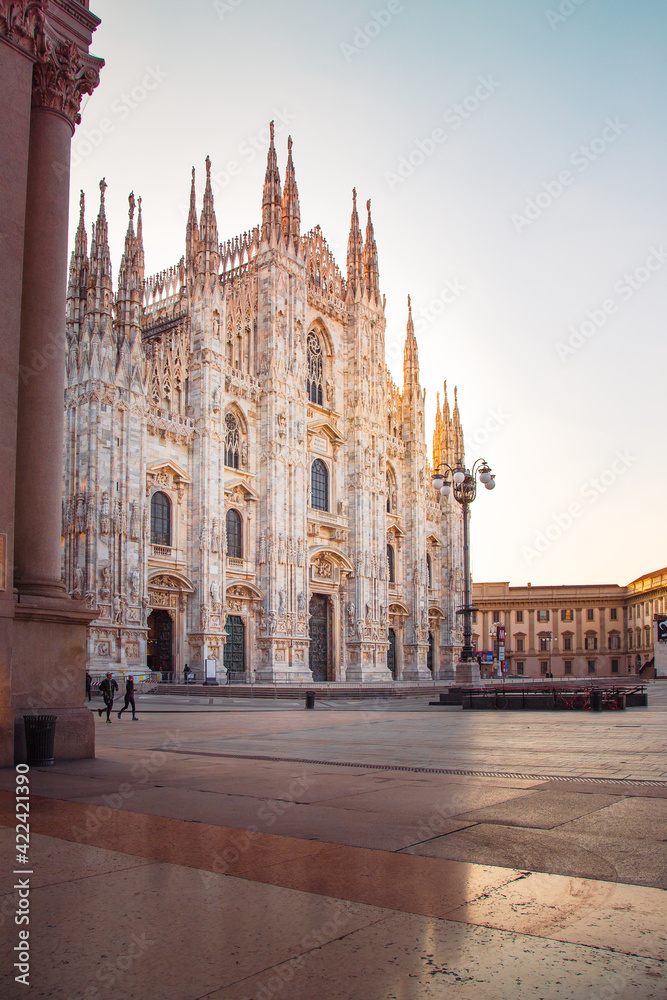 Milan Cathedral (Duomo di Milano) with light flare and couple of people running