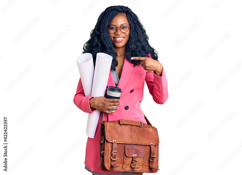 Beautiful african american woman holding paper blueprints and drinking coffee smiling happy pointing with hand and finger Beautiful african american woman holding paper blueprints and drinking coffee smiling happy pointing with hand and finger