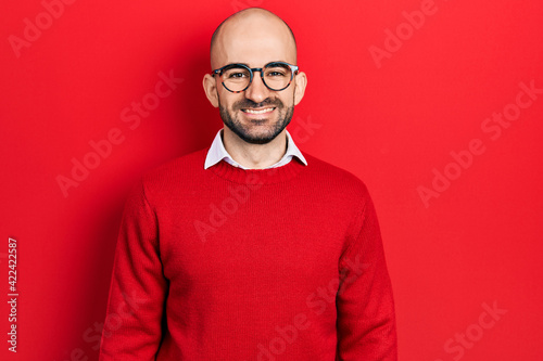 Young bald man wearing casual clothes and glasses with a happy and cool smile on face. lucky person. © Krakenimages.com