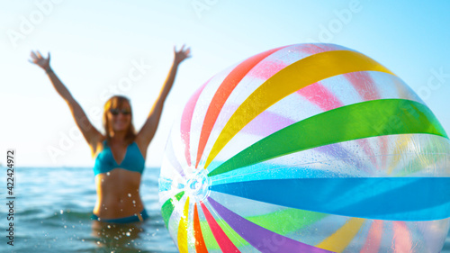 CLOSE UP: Excited female tourist enjoys vacation by playing with colorful ball © helivideo