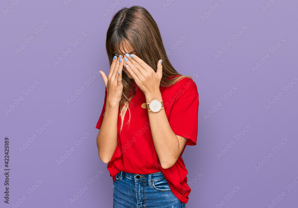 Teenager caucasian girl wearing casual red t shirt rubbing eyes for fatigue and headache, sleepy and tired expression. vision problem Teenager caucasian girl wearing casual red t shirt rubbing eyes for fatigue and headache, sleepy and tired expression. vision problem