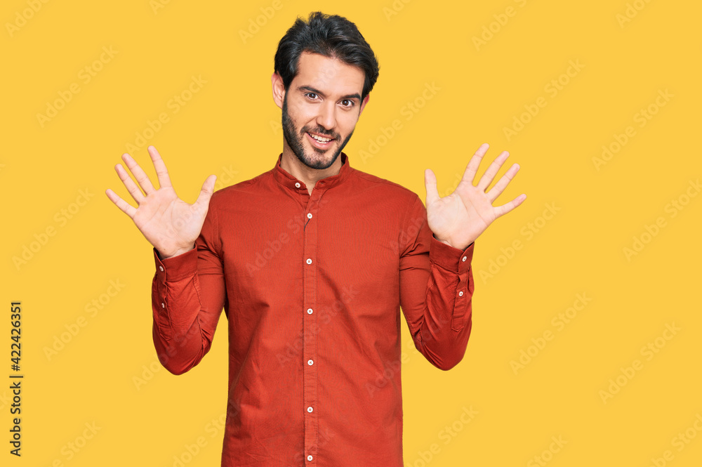 Young hispanic man wearing casual clothes showing and pointing up with fingers number ten while smiling confident and happy. Young hispanic man wearing casual clothes showing and pointing up with fingers number ten while smiling confident and happy.
