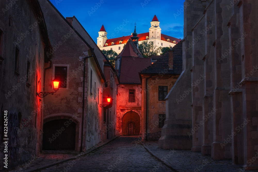 Farska Street with Street Lights in Historical Centre of Bratislava, Slovakia at Night with Bratislava Castle in Background