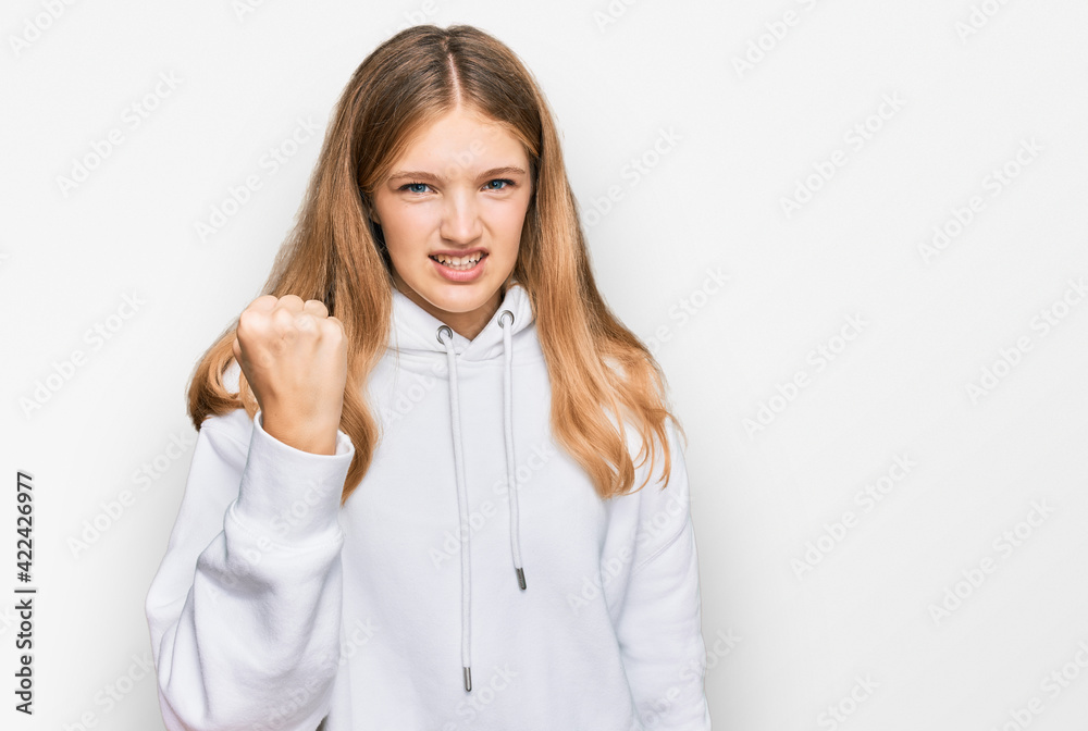 Beautiful young caucasian girl wearing casual sweatshirt angry and mad raising fist frustrated and furious while shouting with anger. rage and aggressive concept. Beautiful young caucasian girl wearing casual sweatshirt angry and mad raising fist frustrated and furious while shouting with anger. rage and aggressive concept.