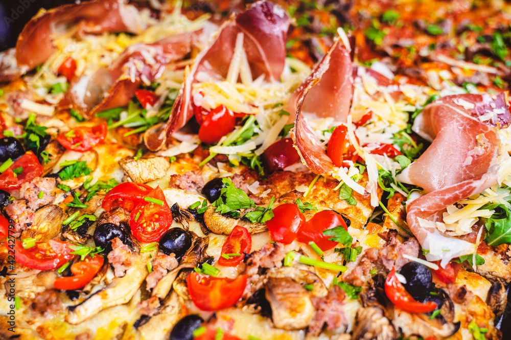 Close up of different gourmet pizza slices with multiple ingredients. Cherry tomatoes, black olives, mushrooms, meat and cheese Close up of different gourmet pizza slices with multiple ingredients. Cherry tomatoes, black olives, mushrooms, meat and cheese