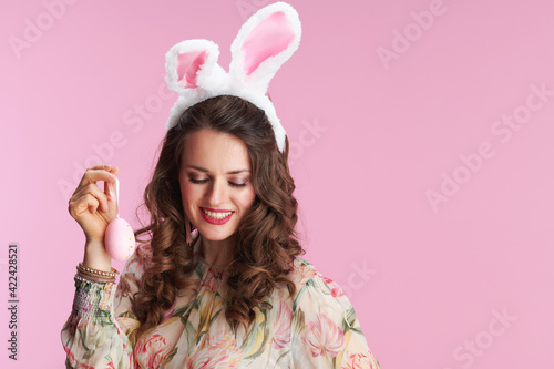 young woman in floral dress with bunny ears on pink