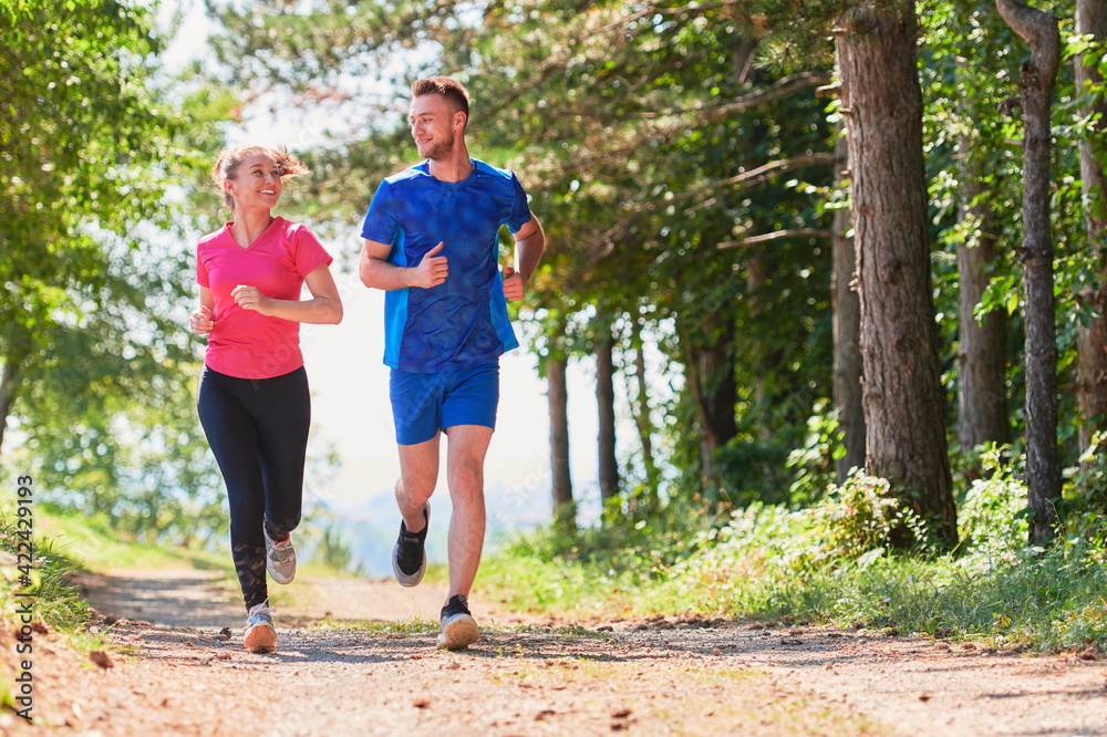 couple enjoying in a healthy lifestyle while jogging on a country road couple enjoying in a healthy lifestyle while jogging on a country road