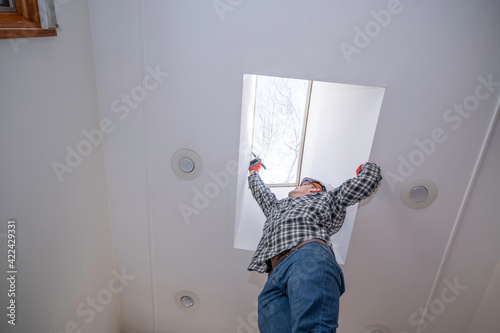 Foto Worker installing moon roof in home