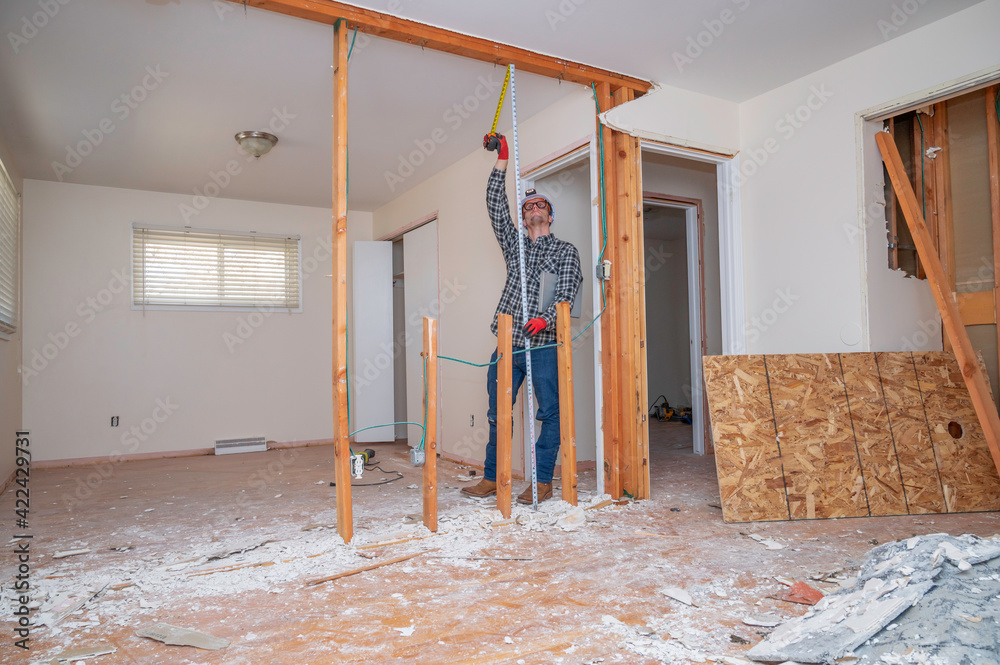 Fototapeta premium Carpenter measuring a demolished room