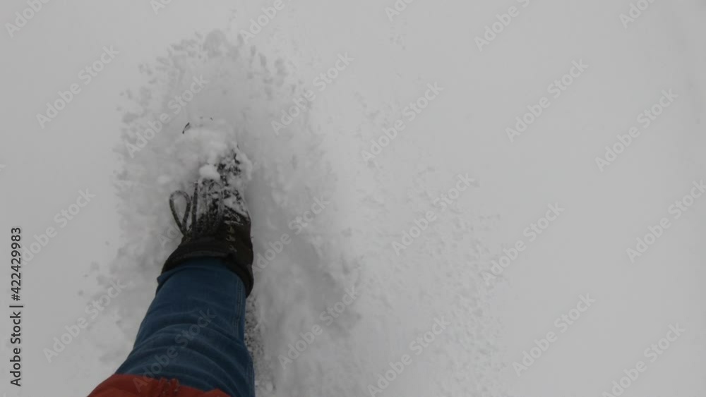 person walking in fresh snow with boots in slow motion
