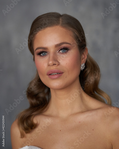 Young beautiful tanned caucasian woman face portrait. Elegant lady with wavy hair hairstyle