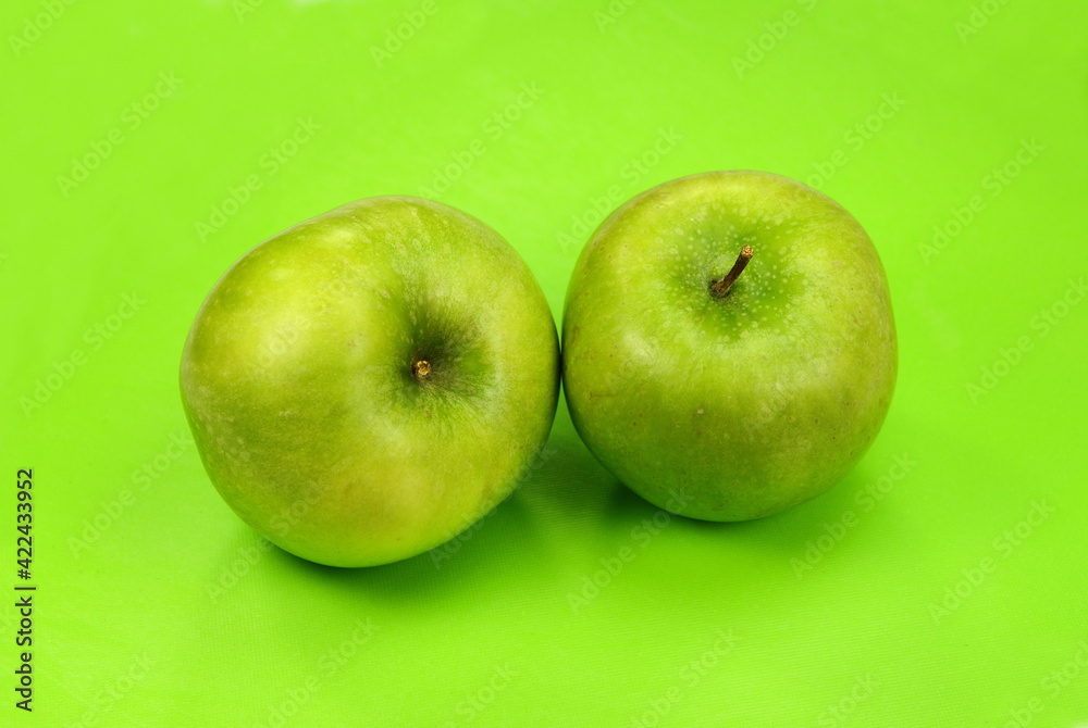 Beautiful natural organic green apple on a green background. Beautiful natural organic green apple on a green background.