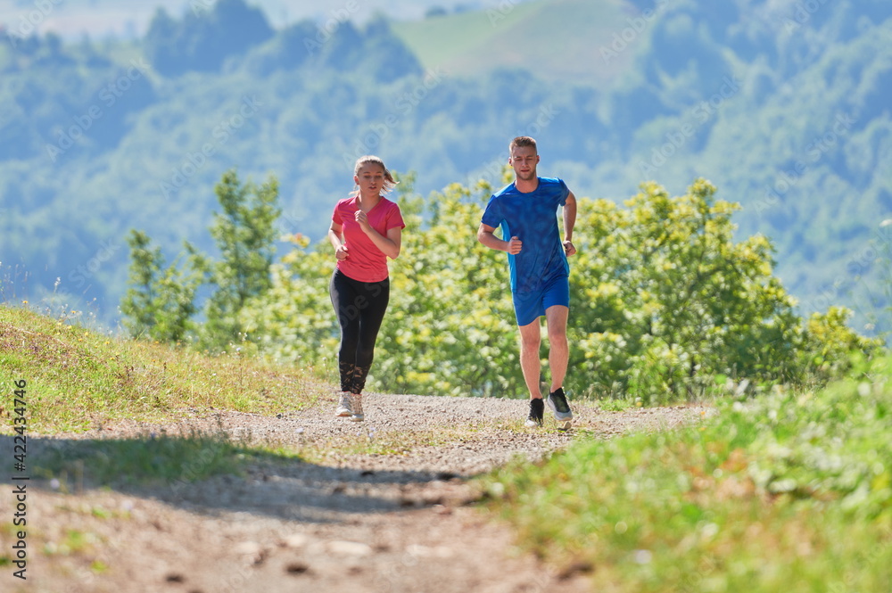 couple enjoying in a healthy lifestyle while jogging on a country road couple enjoying in a healthy lifestyle while jogging on a country road
