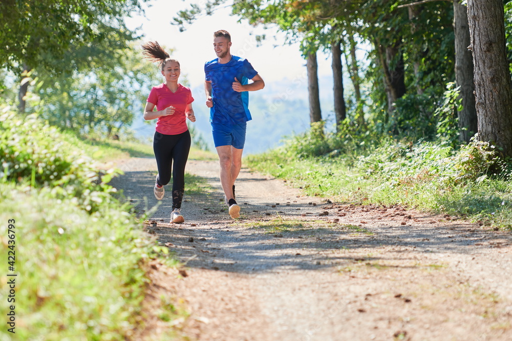 couple enjoying in a healthy lifestyle while jogging on a country road couple enjoying in a healthy lifestyle while jogging on a country road