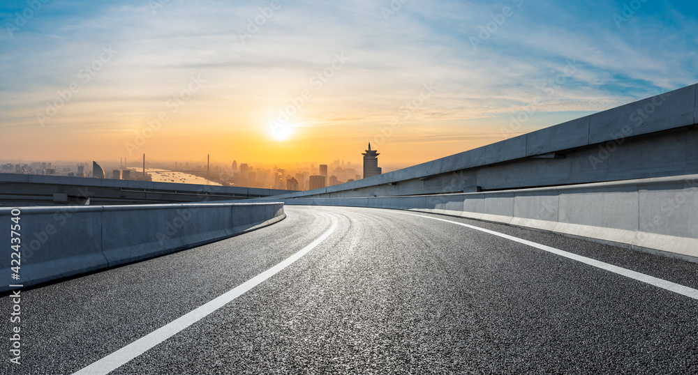 Fototapeta premium Asphalt road and city skyline at sunrise in Shanghai.