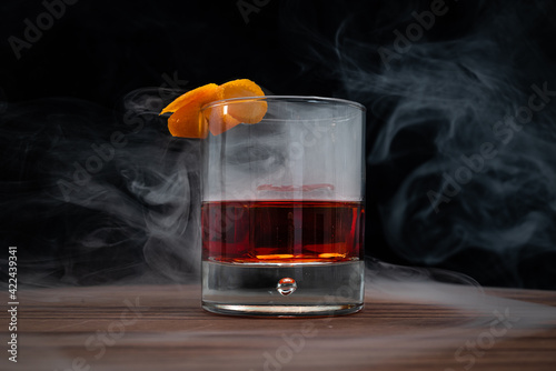 Smoked Negroni on a wooden table with a black background photo