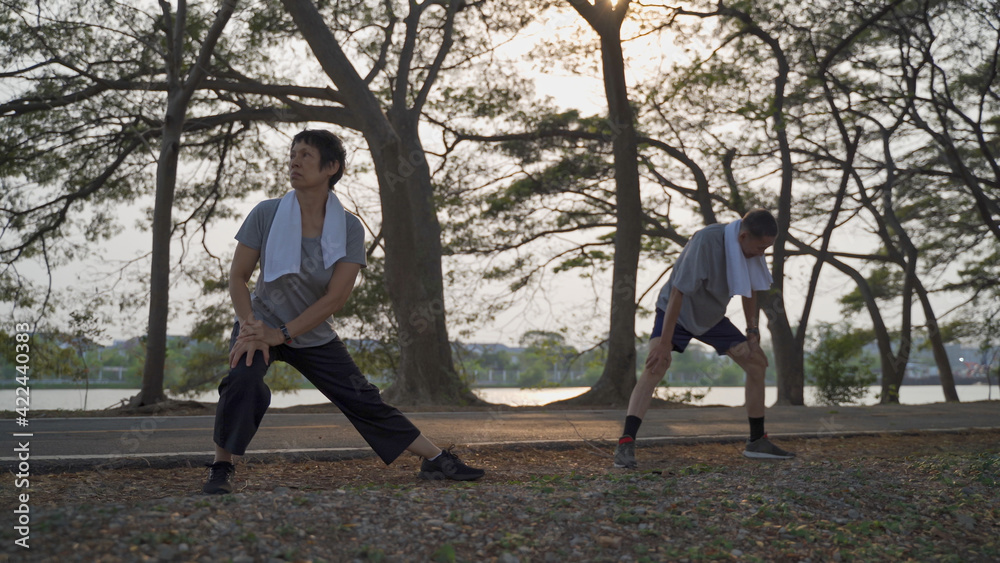 active senior couple exercise and stretching at park in sunset. active senior couple exercise and stretching at park in sunset.